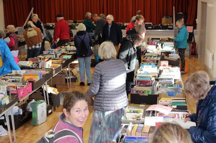 People browsing the long tables full of boxes of books.  SR 9478

