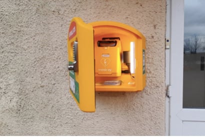 The defibrillator on the wall outside Sandford Parish Hall.