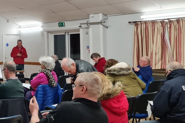 At the meeting, Steve Chambers standing right (in red) and Martin Rich, left, by the stage.