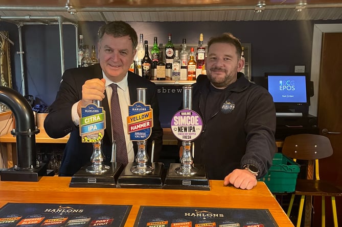 Mel Stride, MP for Central Devon and Secretary of State for Work and Pensions, left, with Dan Taylor from Hanlon’s Brewery.  Image: supplied
