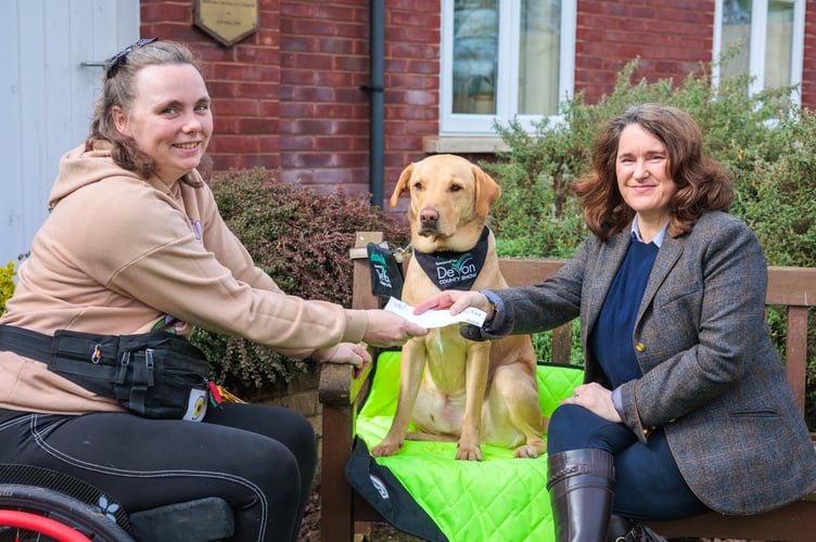 Lisa Moore (right), Show Manager, Devon County Show, presents Chloe Hammond with a cheque for £1,000 towards the upkeep of her assistance dog, Ocho.
