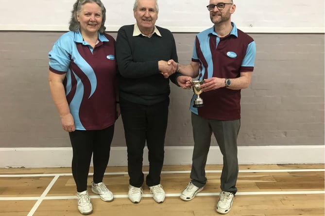The Captain’s Cup being presented to Allan Gibb, right, by the club’s captain, David Pennington, with Jayne Grover, left,
