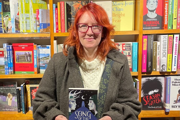 Lucy Holland with a copy of her book.
