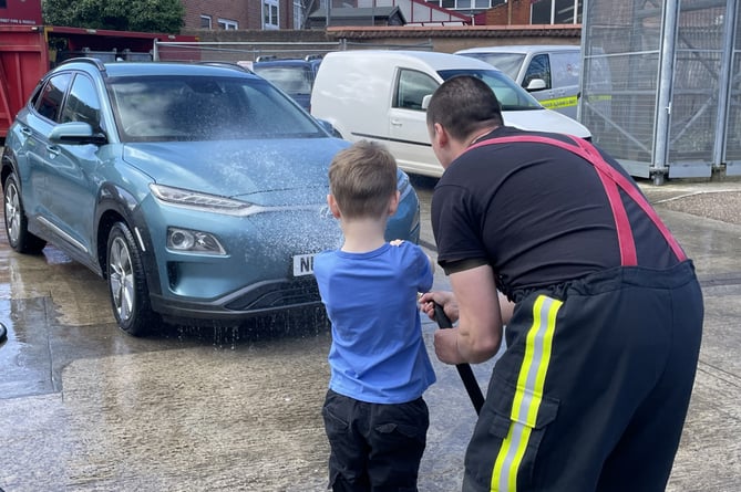 A youngster ‘had-a-go’ at spraying the hose to wash a car.  AQ 9206
