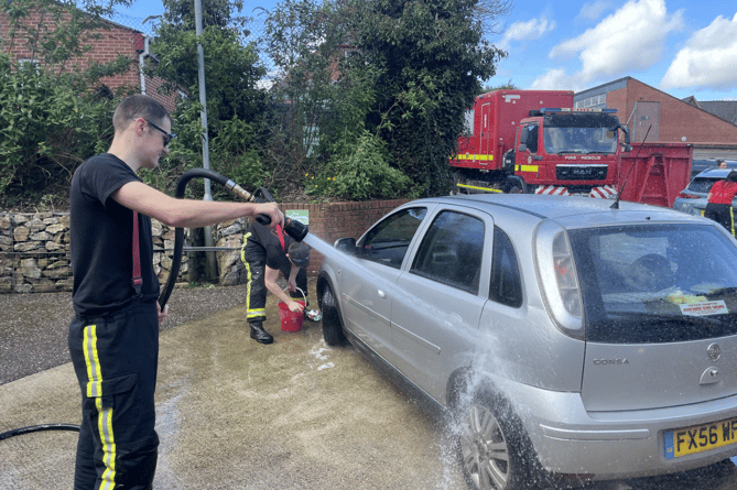 Hosing away the bubbles after a car had been washed.  AQ 9187