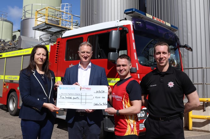 Bethan Parsley and Chris Hume of Crediton Dairy present £500 cheque to firefighters Neil Hargreaves and Ben Talbot