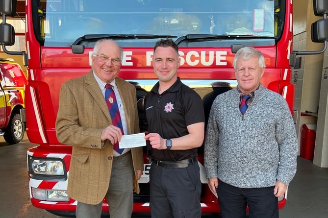 Crediton Freemasons, Phil Eakers, left, and former Crediton firefighter Alan Tonkin, right, presented Neil Hargreaves with a generous cheque towards his fundraising for The Fire Fighters Charity.
