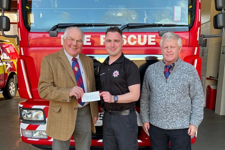 Crediton Freemasons, Phil Eakers, left, and former Crediton firefighter Alan Tonkin, right, presented Neil Hargreaves with a generous cheque towards his fundraising for The Fire Fighters Charity.