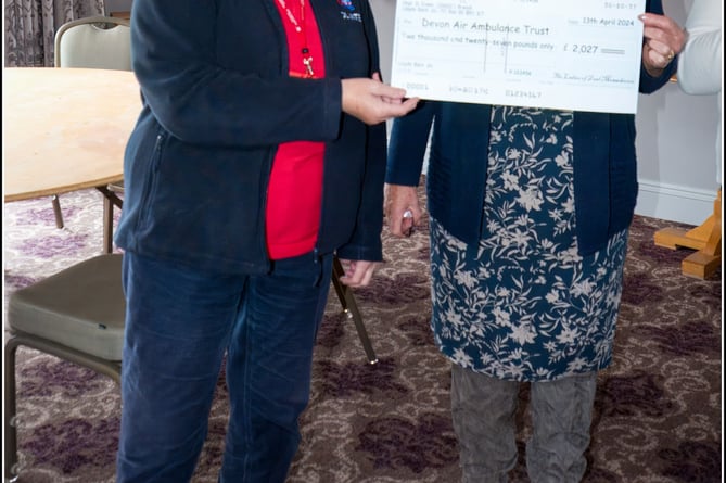Marilyn MacQueen from Devon Air Ambulance, left, receives the cheque from the event from Mandy Smith, one of the five organisers.

