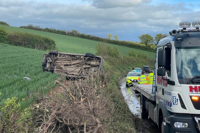 The car on its side in a field near Crediton.  AQ 1344
