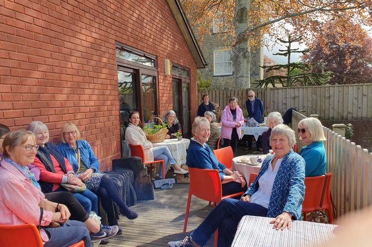 Enjoying refreshments on the decking area at Crediton Library.