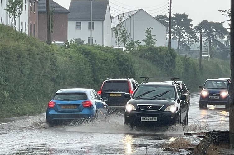Driving with care through floods in Exeter Road, Crediton.  AQ 3069
