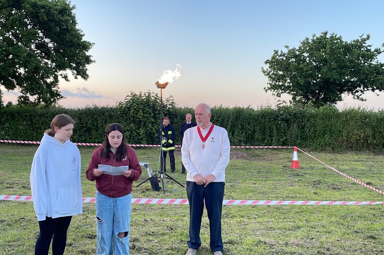 Bella Gurney reading tribute in front of lit beacon with Deputy Mayor Steve Huxtable, right