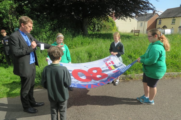 Vicar David Spence and North Tawton schoolchildren with D-Day 80 flag