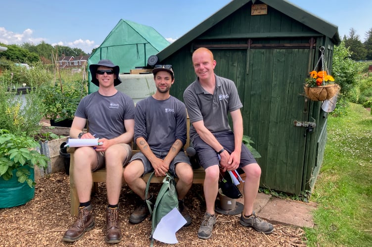 The three Crediton allotment judges, Lawrence Weston,  Rob Coate and Peter Adams sitting on a bench on one of the winning plots on Exhibition Road.
