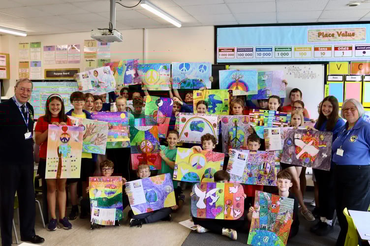 Landscore pupils holding their peace posters with Eric Parkes and Ann Whitehouse of Crediton Lions Club