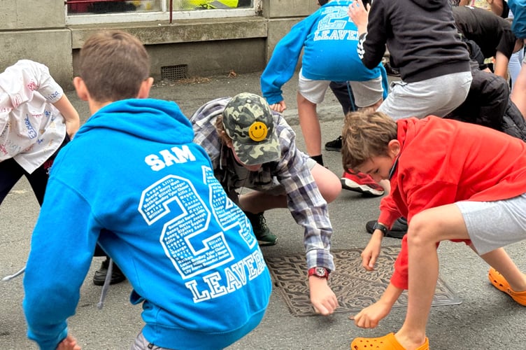 Children in one of the age groups picking up money thrown from the Town Hall for the money scramble. AQ 8343