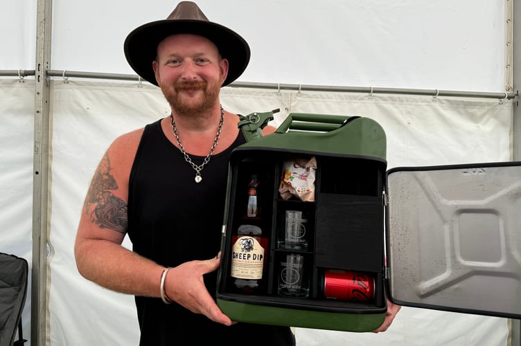 Gregory Gosden from Wild Cabin Creations of Chagford had a stall featuring his engraved wood carving and upcycled metal products, including his bar in a jerry can, which proved popular. AQ 0702
