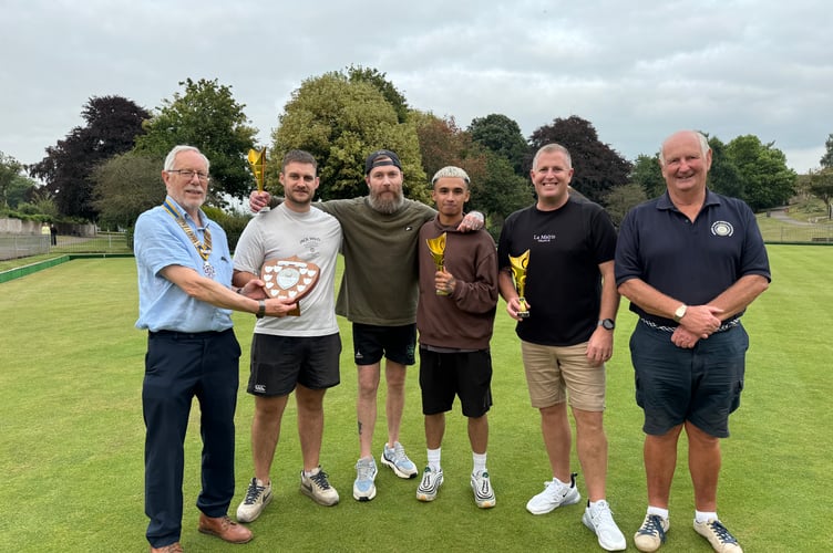 Fred Oliver, President of Crediton Boniface Rotary, left, presenting the winners trophy in the Industrial Bowls tournament to, from second left, Ross Storie, Simon Roberts, James Davis and Rob Paxton, with, right, Rotarian Paul Radnor, one of the tournament organisers. AQ 1176