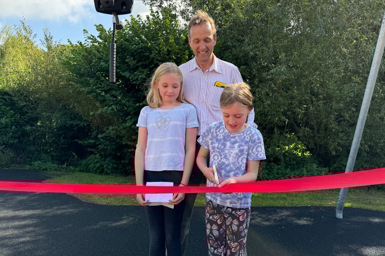 Freya and Sibbie cutting the ribbon to open the new play equipment. AQ 1375