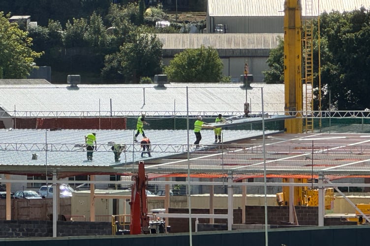 Contractors putting in the roofing sheets craned to them on the Crediton Lidl store roof. AQ 2566