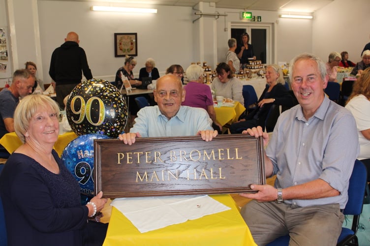 Peter behind the name plaque with (left) Margaret Jones and (right) Hall treasurer Clive Stacey. SR 9679