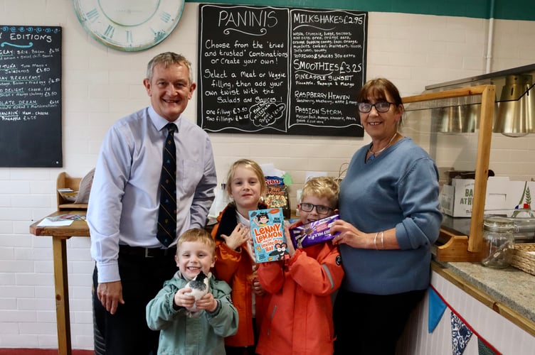 Crediton Courier Editor Alan Quick, Elaine Gregory of The Sandwich Shop with runners-up of the Clouston family