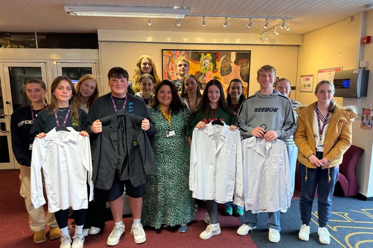Tamlyn Fraiquin, Crediton Community Builder, Involve Mid Devon, centre, with the QE 6th Form students who have launched a pre-loved school uniform store.  AQ 3920