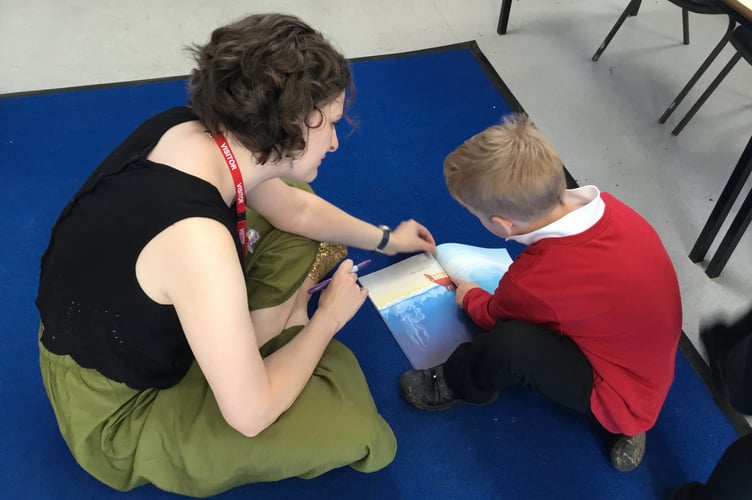 Author Chloe Savage helping a pupil at Lapford Community Primary School.
