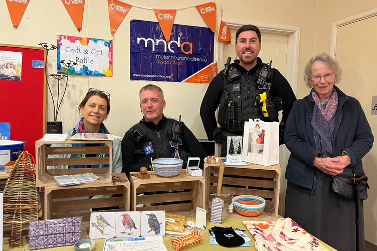 Sandford School headteacher, left, ran the raffle, pictured with police and a visitor to Sandford Craft Fair.
