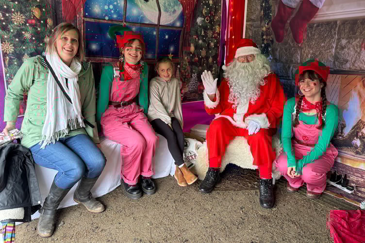 Father Christmas and his elves and a visitor with a mum.  AQ 8788