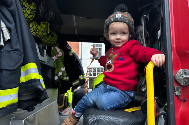 A youngster enjoyed sitting in the fire engine.  AQ 8902