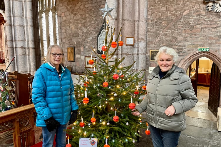 Edna Beasley, left, and Ann Burnett decorated Yeoford Yarns' tree. It featured handmade Christingle ornaments (Will Goddard, Crediton Courier)