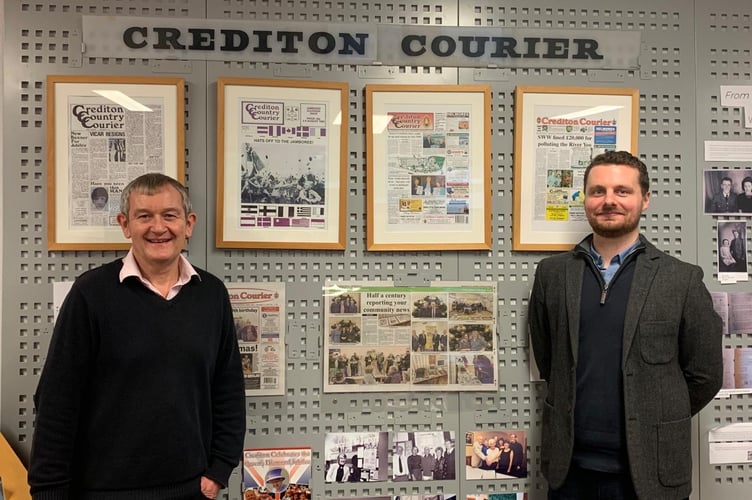 Courier Editor Alan Quick, left and Reporter Will Goddard, in front of the wall display to mark 50 years of the Crediton Courier at Crediton Library.
