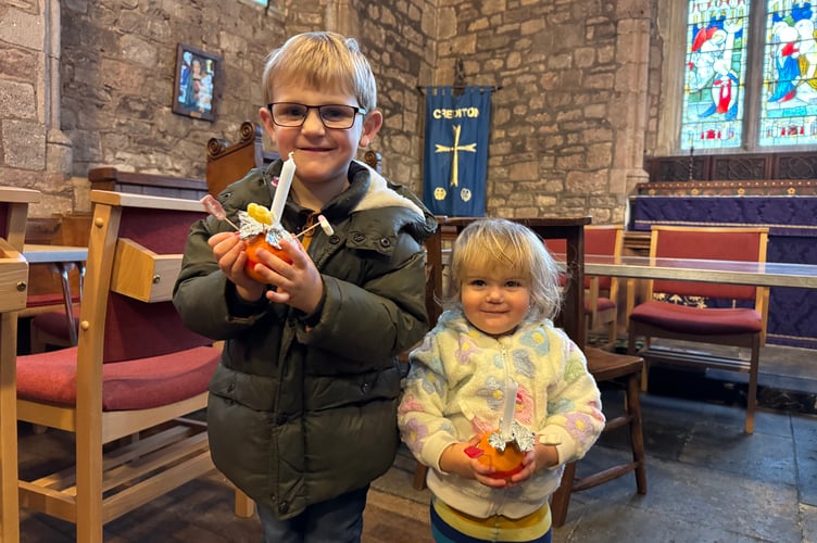Proudly holding their Christingles, two youngsters ready for the service.  AQ 0113

