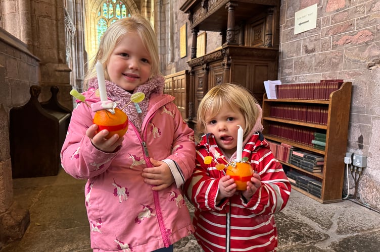 Two youngsters holding the Christingles they made.  AQ 0100
