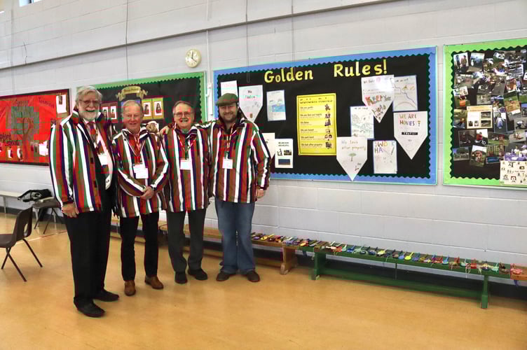 From left, Roger Haywood, Mike Wisdom and Brian Drake of Wooden Spoon and donor Barny Butterfield with decorated wooden spoons along bench