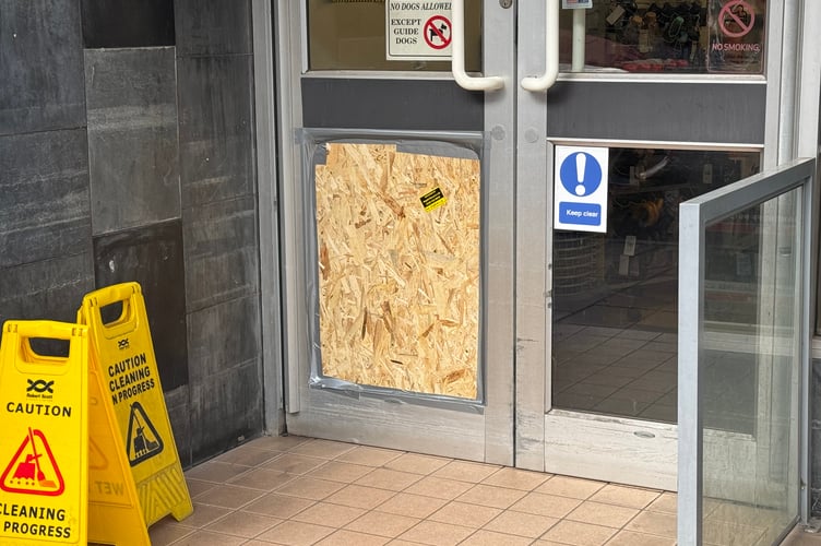 The repair to the glass door at the front of the Crediton Boots Pharmacy.  AQ 3461

