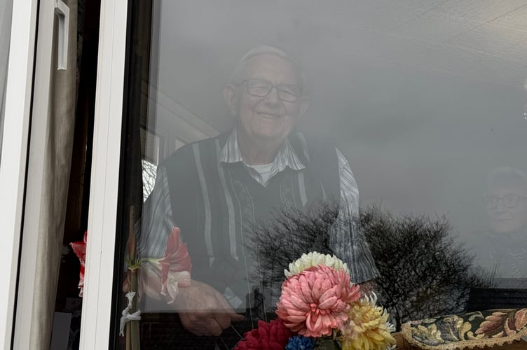 Reg watching and listening to Crediton Town Band play outside for his 100th birthday.  AQ 3516
