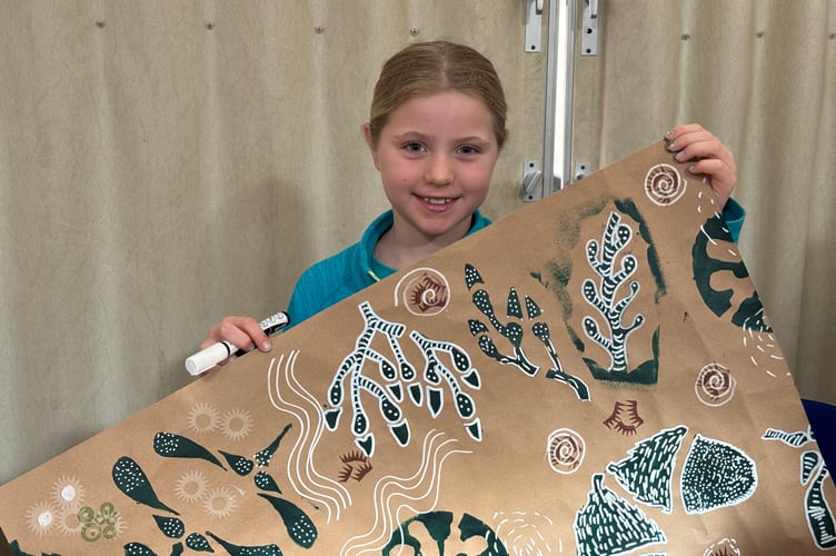 Edith Steer (8), with wrapping paper she helped to decorate.  AQ 4436
