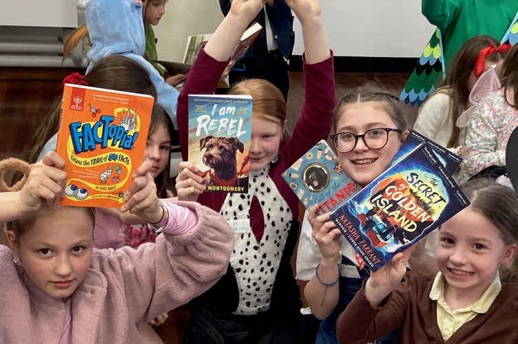 Pupils with their chosen books including a non-fiction title along with some adventure books