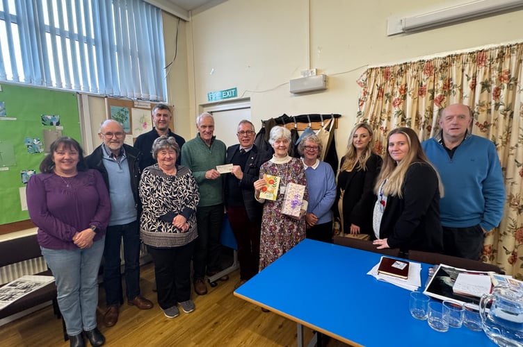 Jenny Berg, centre right, with her gifts and Phil Hutchens, centre, receiving the £500 cheque from Gary Adams from the Rotary Club of Crediton Boniface.  AQ 2603
