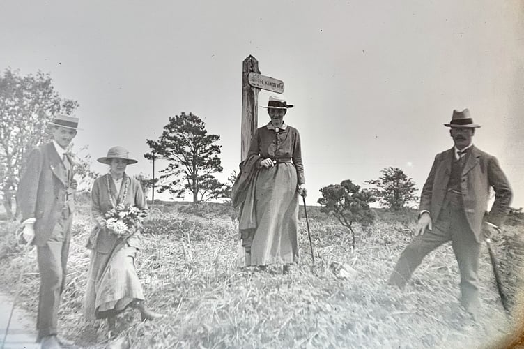 A group standing by a sign, possibly on a walk
