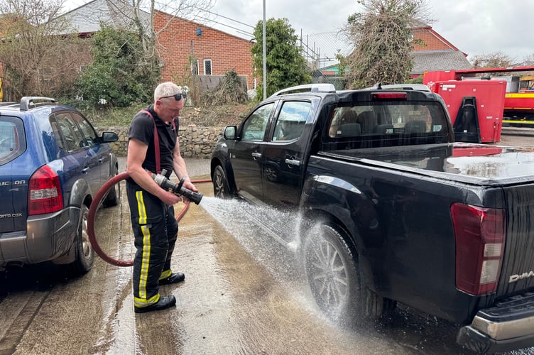 Hosing down another vehicle at the car wash. AQ 7588
