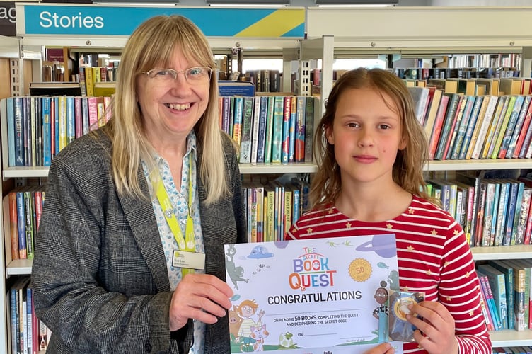 Jessica receiving Secret Book Quest certificate from Supervisor Sue Lee at Crediton Library