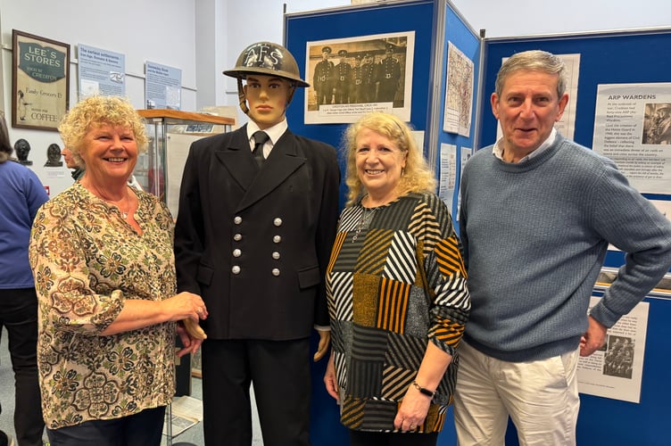 Susan Sparham, left and Rickie Pawsey, with the model of the Auxiliary Fire Service fireman with John Heal, right, at Crediton Museum.  AQ 8354
