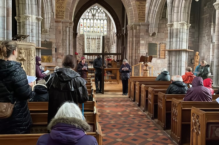 Listening to a Bible reading at Crediton Parish Church