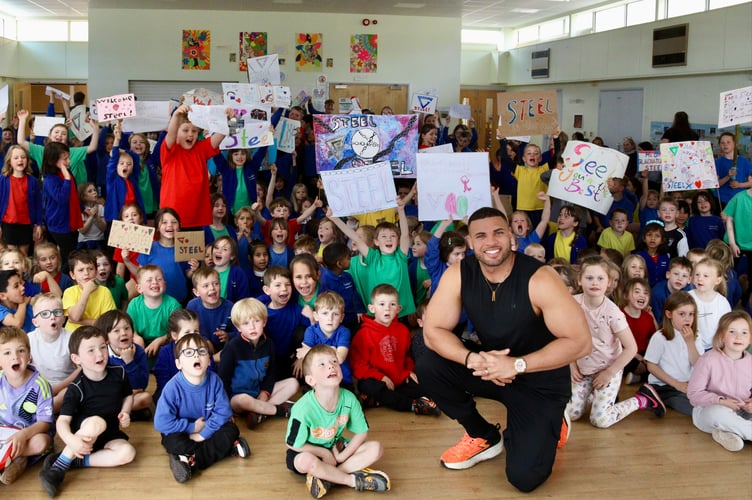 Mr George and Landscore pupils with posters they made to welcome him