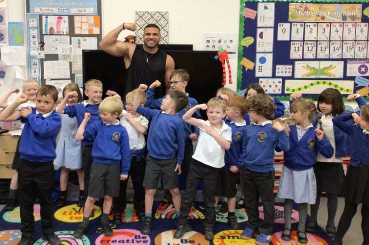 Mr George and Cheriton Fitzpaine Primary School pupils flexing their biceps