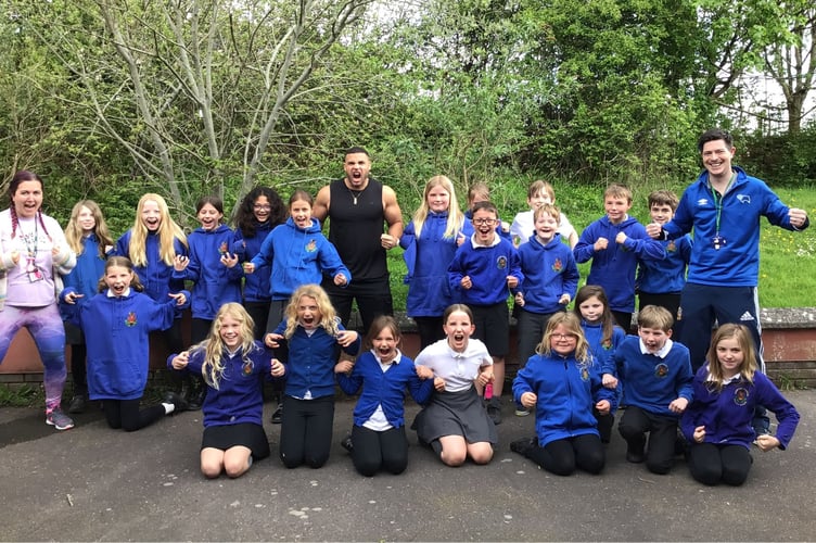 Mr George and Cheriton Fitzpaine Primary School students and staff doing Steel's signature pose
